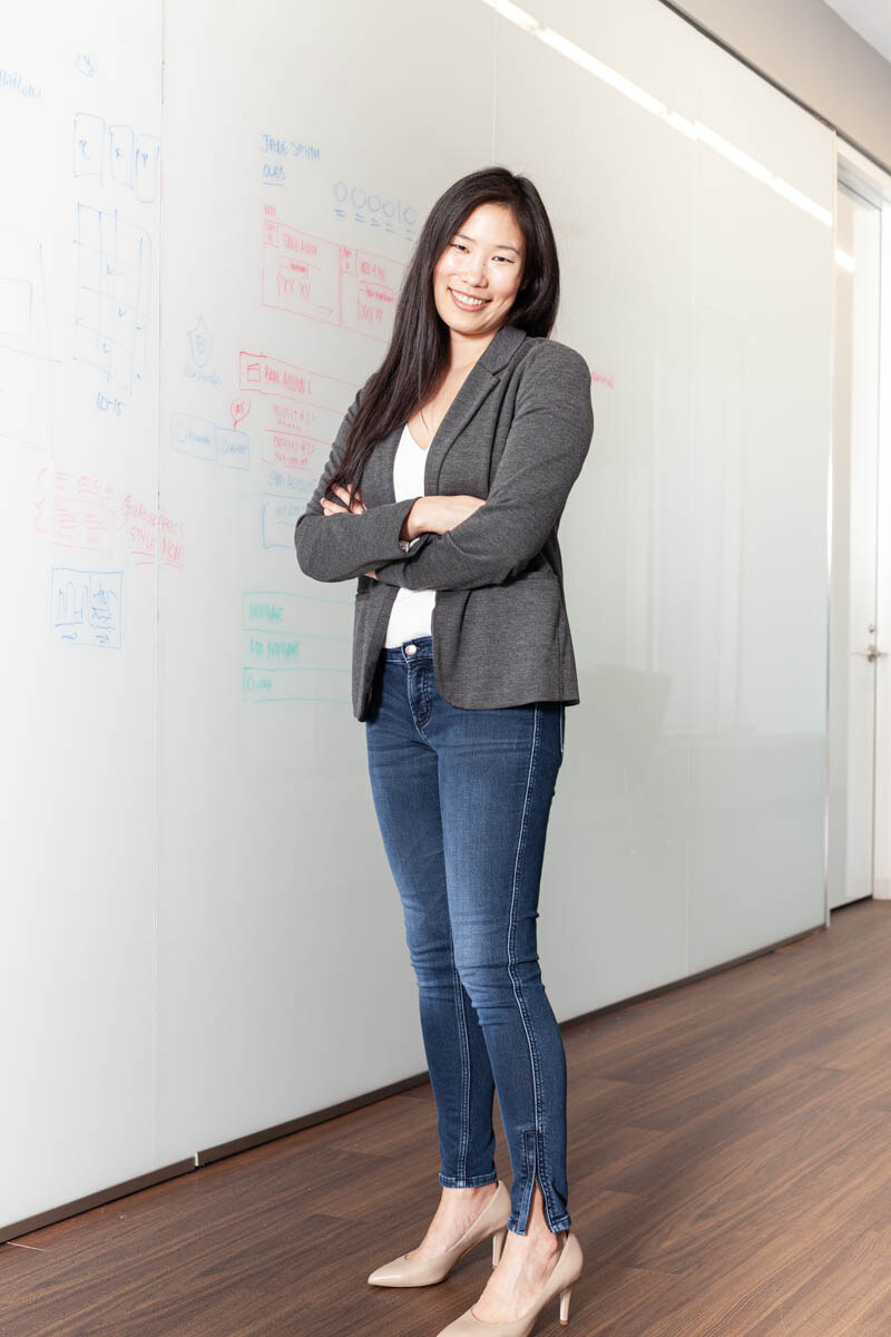 Andrea Yip standing in front of a whiteboard covered in sketches