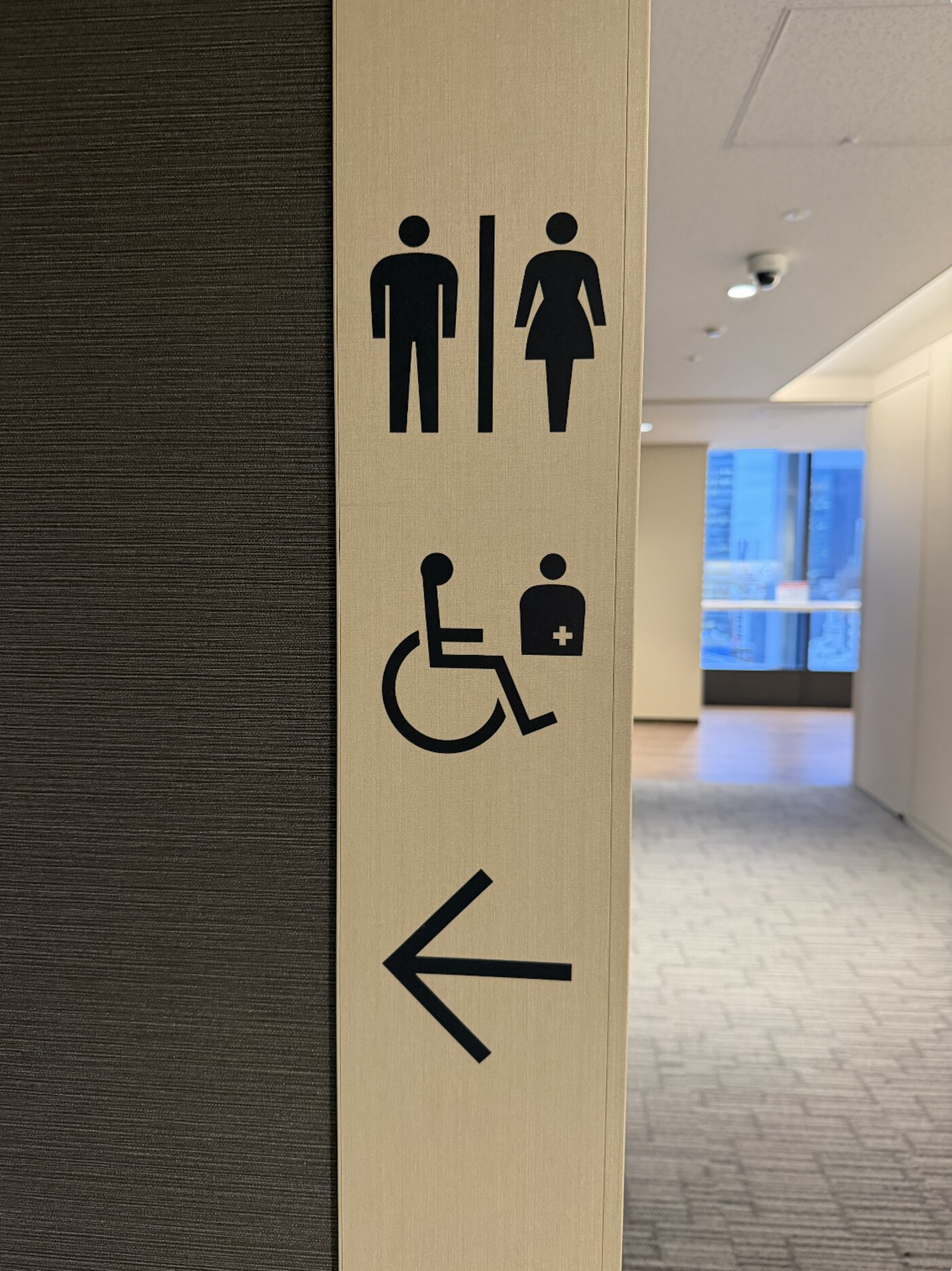 Restroom signage on a wall pointing toward the washrooms